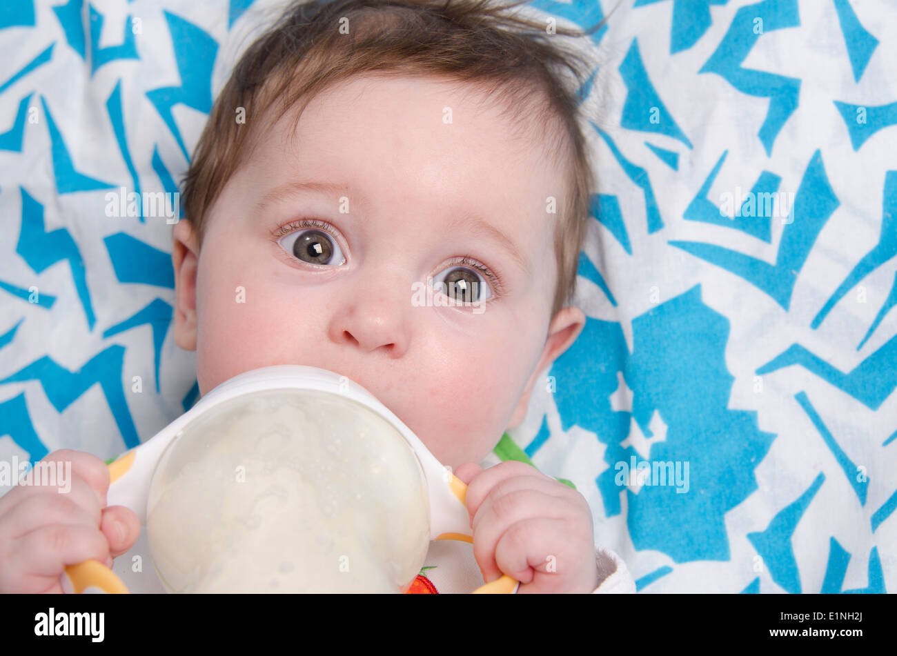 Sechs Monate altes Baby trinken Milch aus der Flasche mit dem Sauger Stockfoto