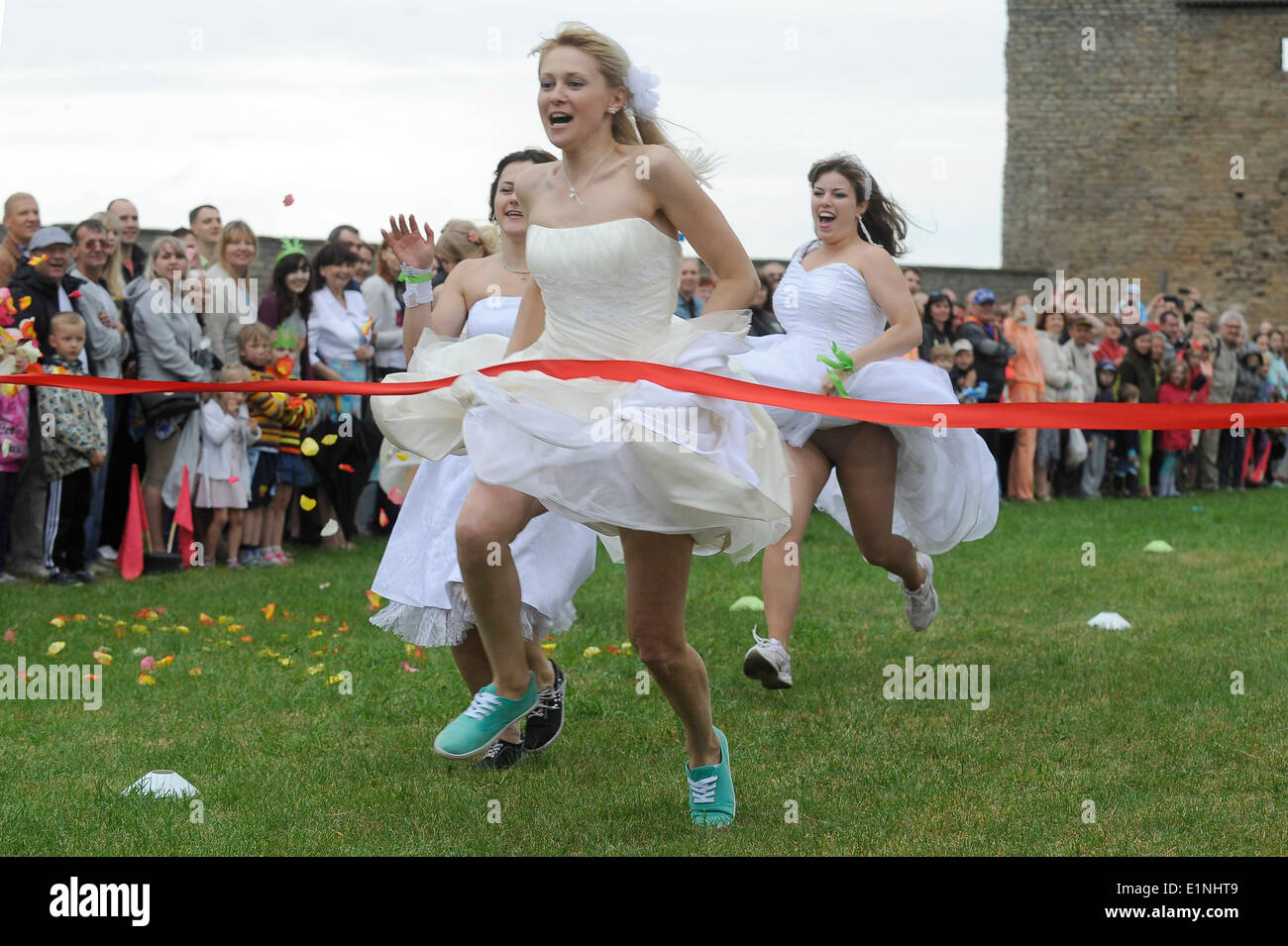 Narva, Estland. 7. Juni 2014. Frauen in Brautkleidern konkurrieren in einem jährlichen Runaway Brides-Wettbewerb in Narva, Estland, 7. Juni 2014. Insgesamt 73 verheiratet und single Frauen aus Estland und Rußland verkleidet als Bräute, die auf einem 50 Meter langen Grass Track hier am Samstag raste. Bildnachweis: Sergei Stepanov/Xinhua/Alamy Live-Nachrichten Stockfoto