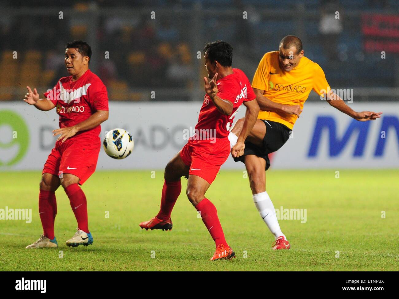 Jakarta, Indonesien. 7. Juni 2014. International-Legends-Team Spieler  Rivaldo (R) schießt den Ball zwischen indonesischen Legends-Team-Spieler  Bejo Sugiantoro (C) und Francis Wewengkang während der Fußball Legenden  Tour 2014 bei Gelora Bung Karno Stadium