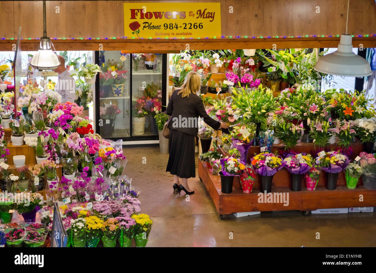 Frau Wahl einen Blumenstrauß in einem Blumenladen (Blumen von Mai) in Lonsdale Quay, North Vancouver, BC, Kanada.  Öffentlichen Markt. Stockfoto