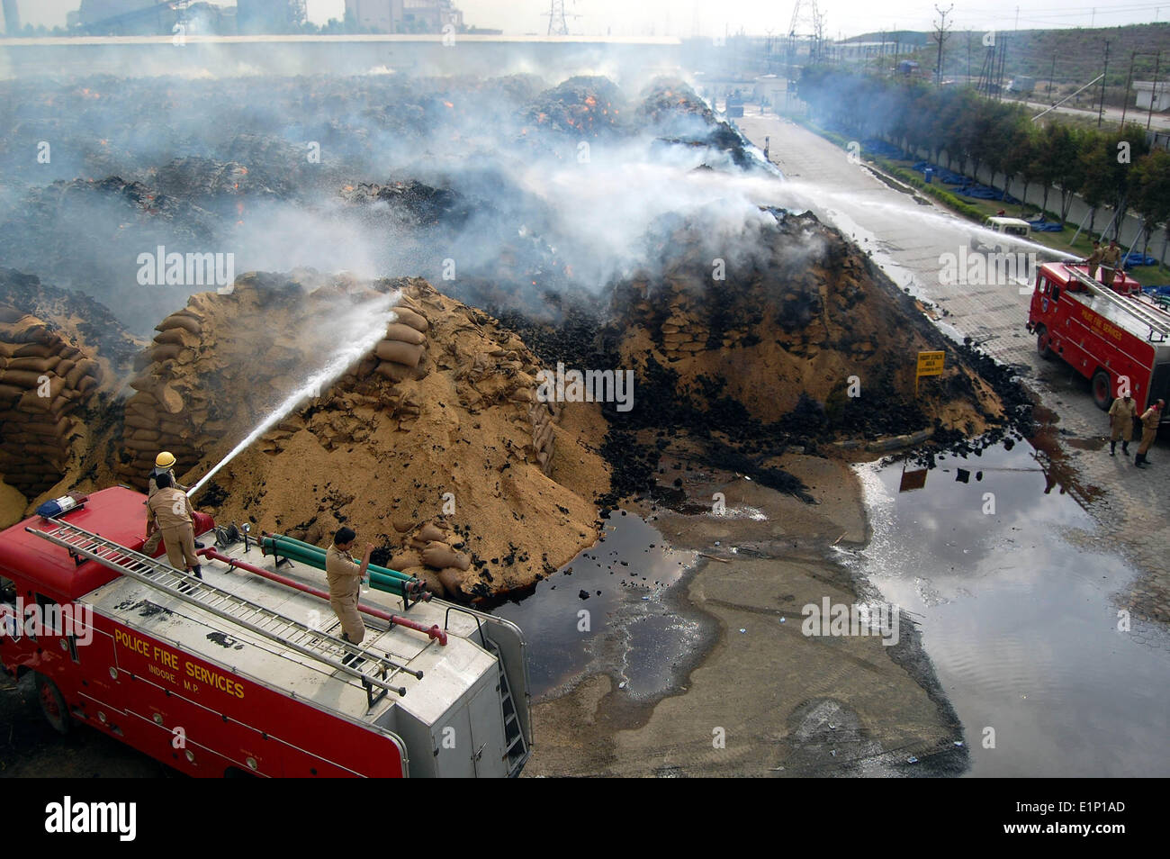 Bhopal, Indien. 7. Juni 2014. Feuerwehrleute versuchen, die Flammen zu begießen, nach ein großer Brand in einer Reismühle Produktion im Industriegebiet Satlapur, etwa 40 km von Bhopal, Indien, 7. Juni 2014 brach. Taschen voller Paddy und Reis in 5 Hektar Land gehalten wurden komplett in den Vorfall beschädigt. © Stringer/Xinhua/Alamy Live-Nachrichten Stockfoto