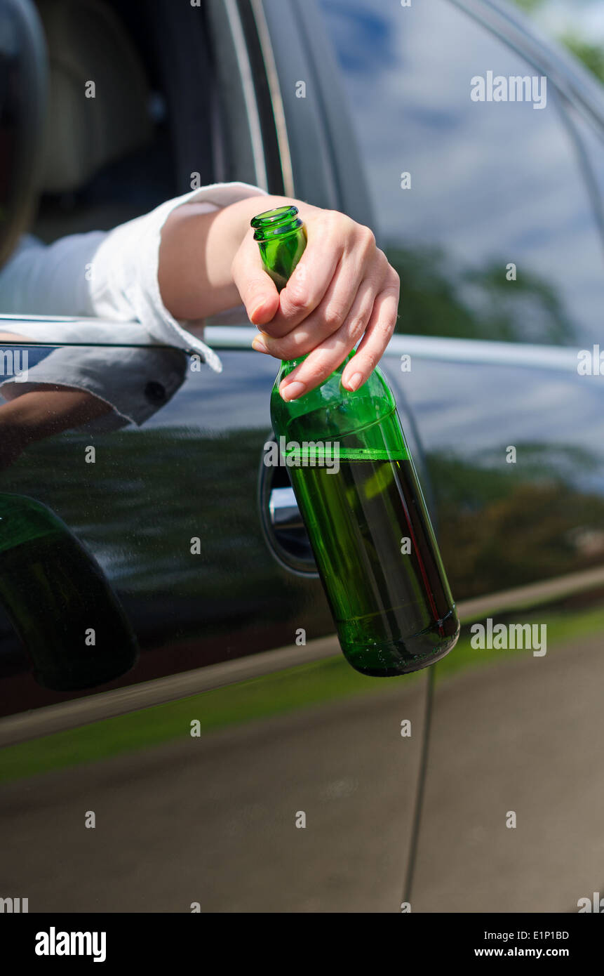 Fahren unter dem Einfluss. Weibliche Hand mit Flasche Bier. Stockfoto