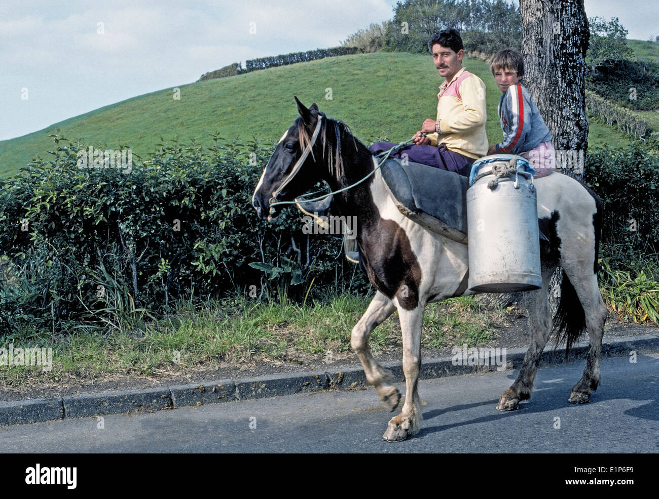 Ein Azoren Mann und sein Sohn reiten um frische Milch für eine Molkereigenossenschaft auf der Insel Sao Miguel auf den Azoren, eine Region in Portugal zu liefern. Stockfoto