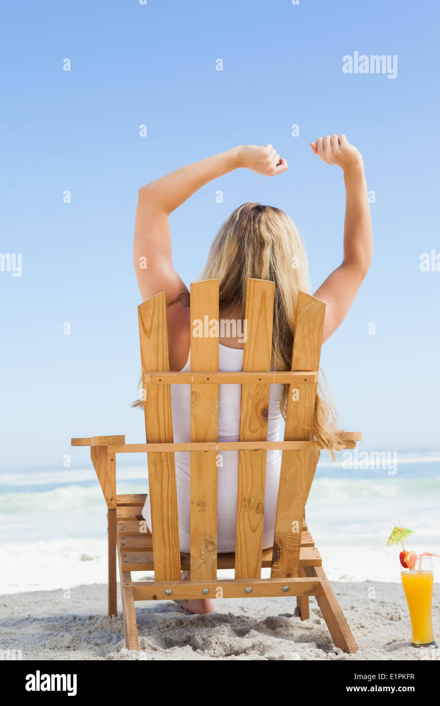Hübsche Blondine sitzt im Liegestuhl mit einem cocktail Stockfoto