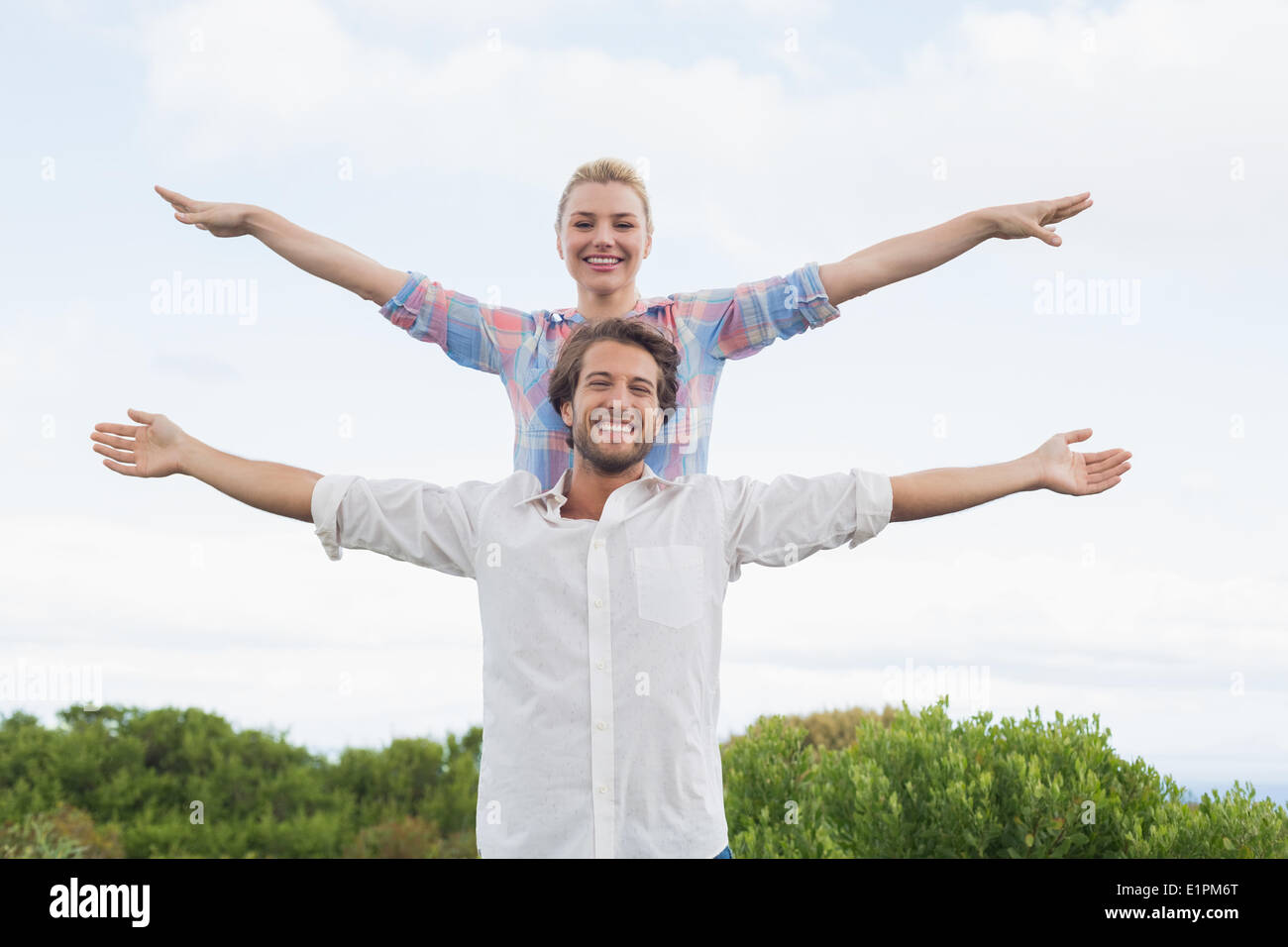 Süßes Paar draußen mit ausgestreckten Armen Stockfoto