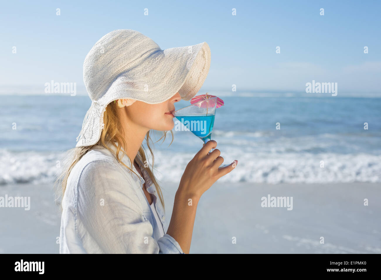 Lächelnde blonde entspannen am Meer cocktail schlürfen Stockfoto