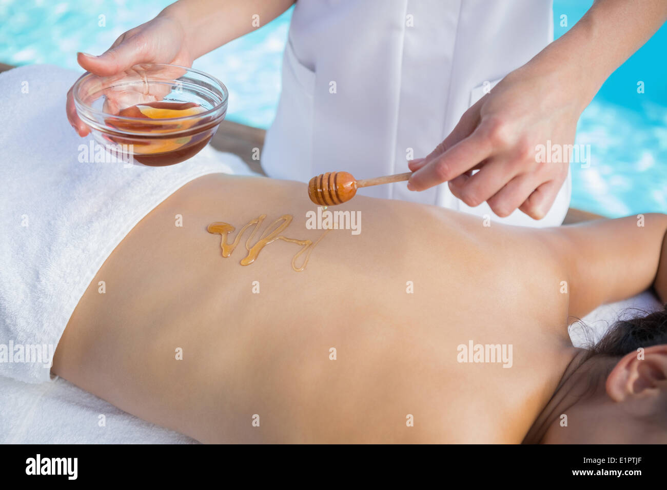 Frau bekommen einen Honig Schönheit Behandlung am Pool Stockfoto