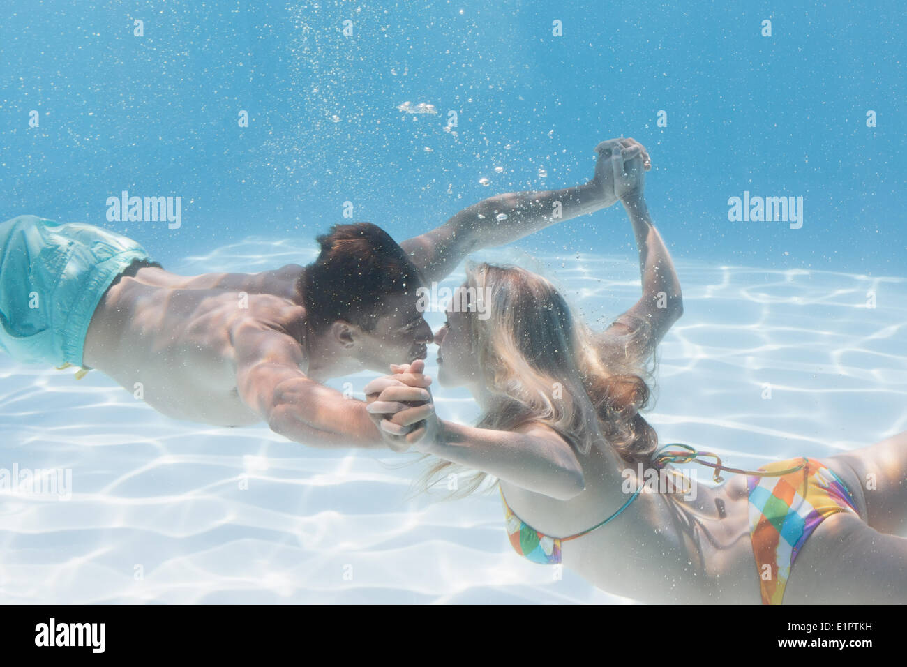 Süßes Paar küssen unter Wasser im Schwimmbad Stockfoto