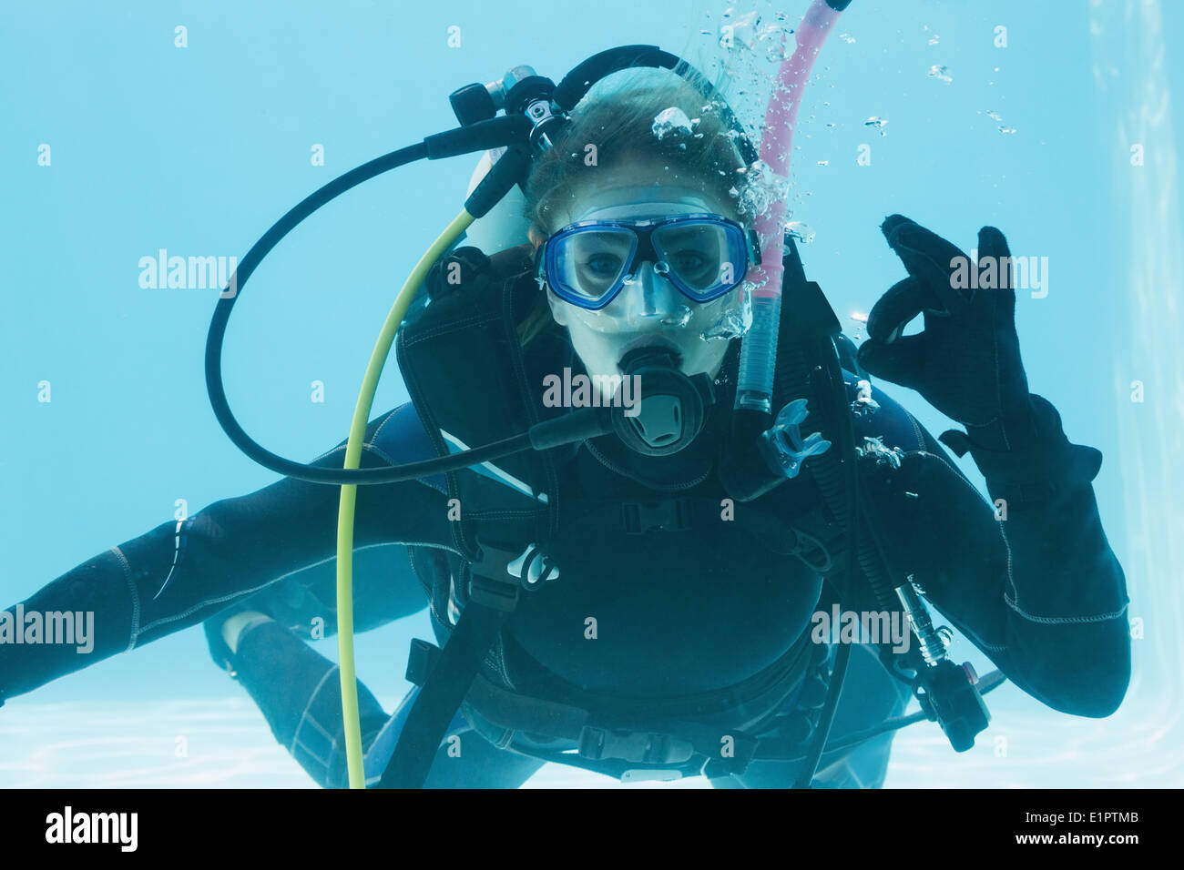 Frau auf Tauchausbildung untergetaucht im Schwimmbad machen ok Sign. Stockfoto