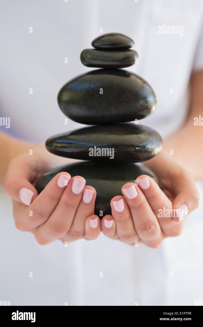 Kosmetikerin mit Steinhaufen für massage Stockfoto