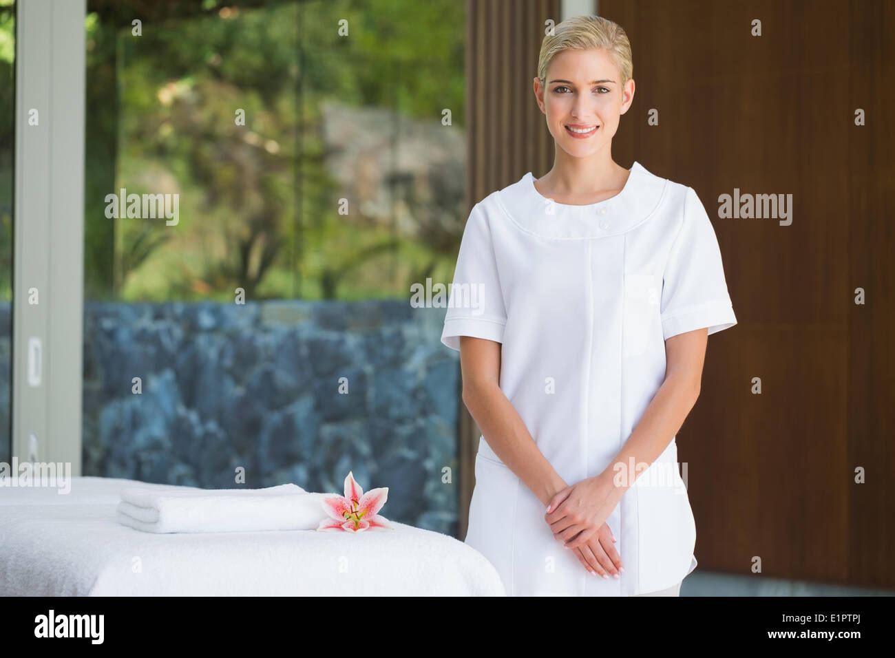 Lächelnde Kosmetikerin neben Massage Handtuch Stockfoto