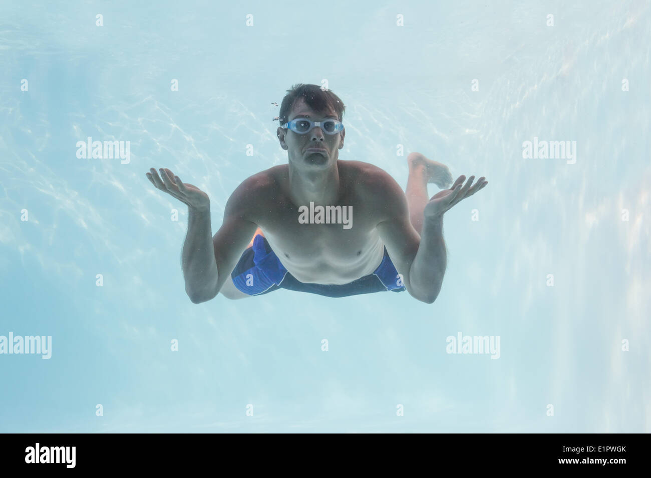 Mann zuckt die Schultern unter Wasser im Schwimmbad Stockfoto