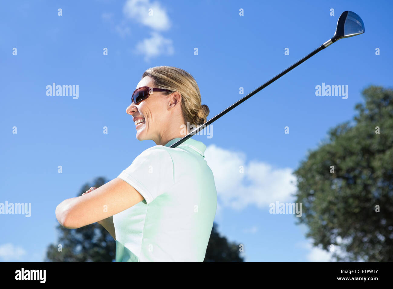 Golfspielerin stehend halten ihr Lächeln Club Stockfoto