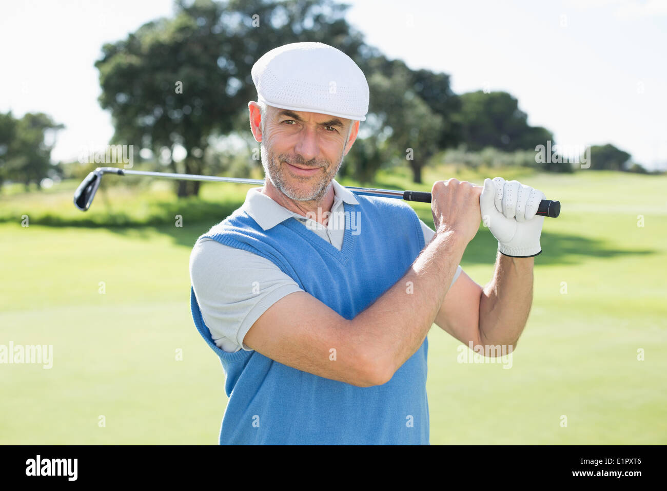 Golfer stehen und seinem Verein in die Kamera Lächeln geschwungen Stockfoto