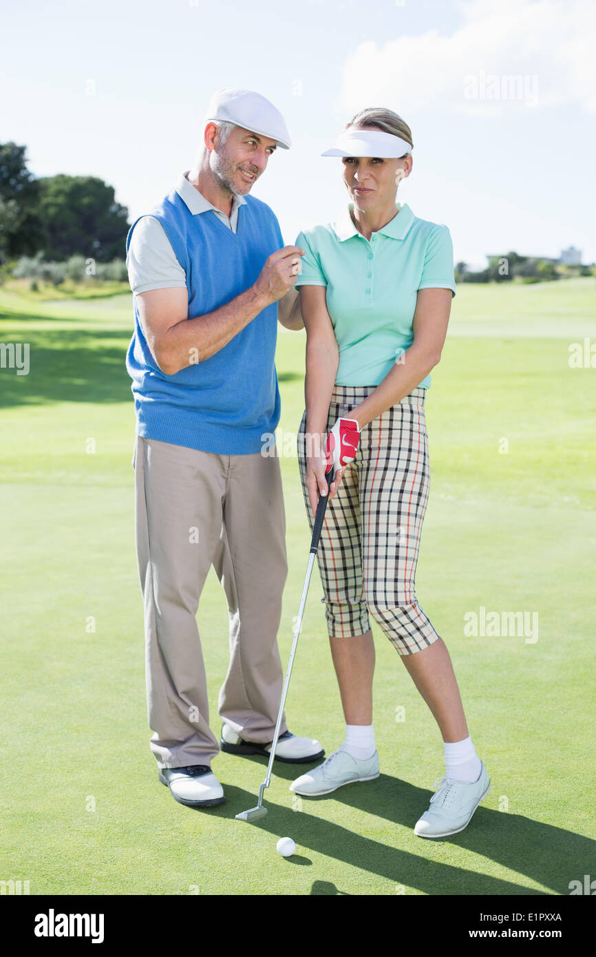 Mann seine Partnerin auf dem Putting Green coaching Stockfoto