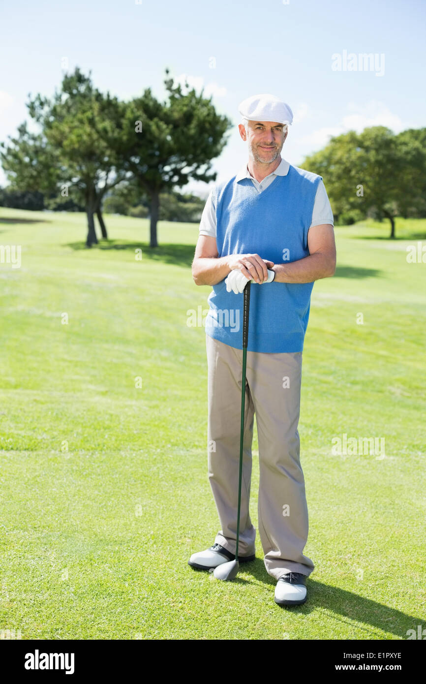 Fröhlich lächelnd in die Kamera hält seinen Club golfer Stockfoto