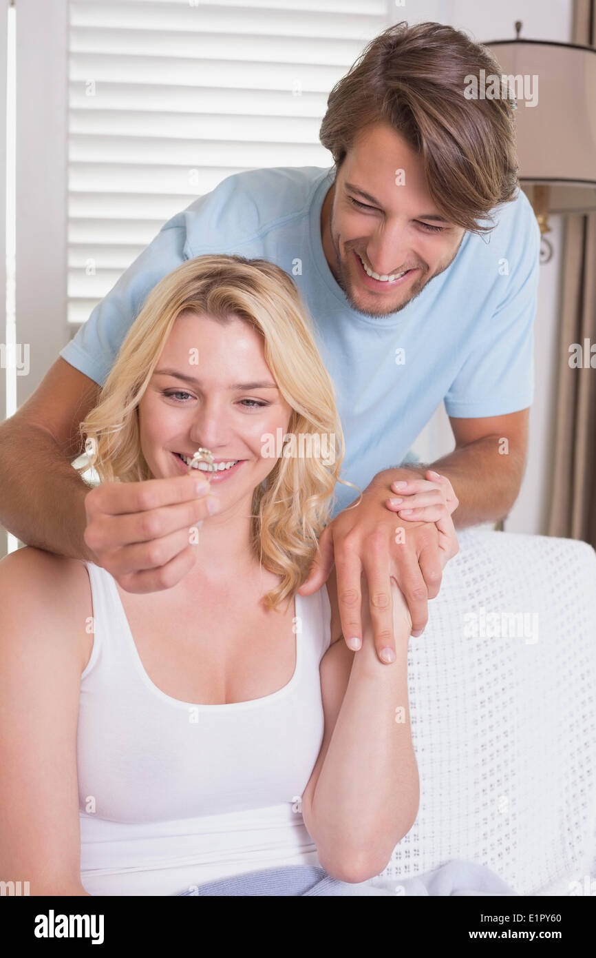 Mann überraschend seine Freundin mit einem Verlobungsring auf der couch Stockfoto
