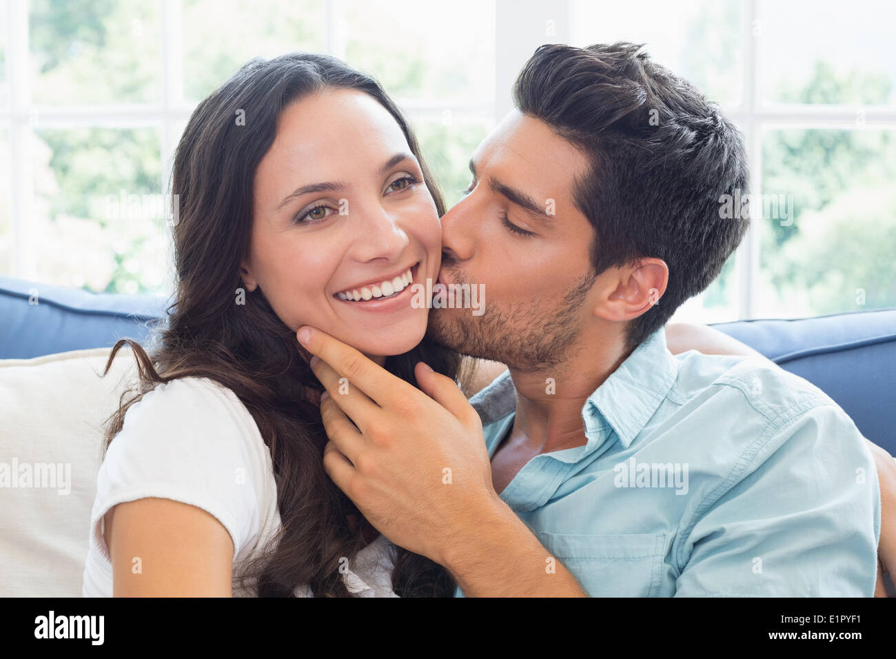 Attraktives Paar auf der Couch kuscheln Stockfoto