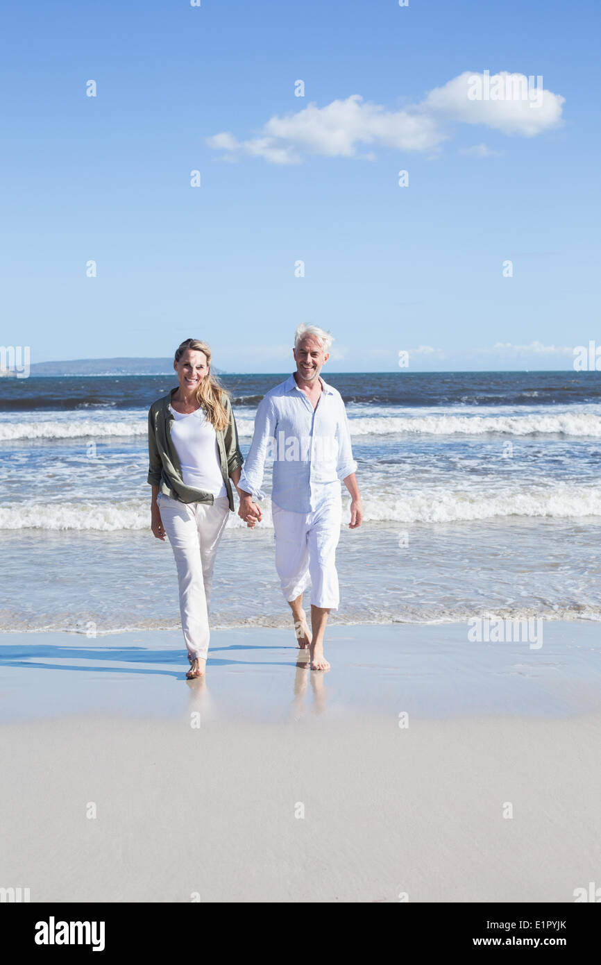 Glückliches Paar spazieren barfuß am Strand Stockfoto