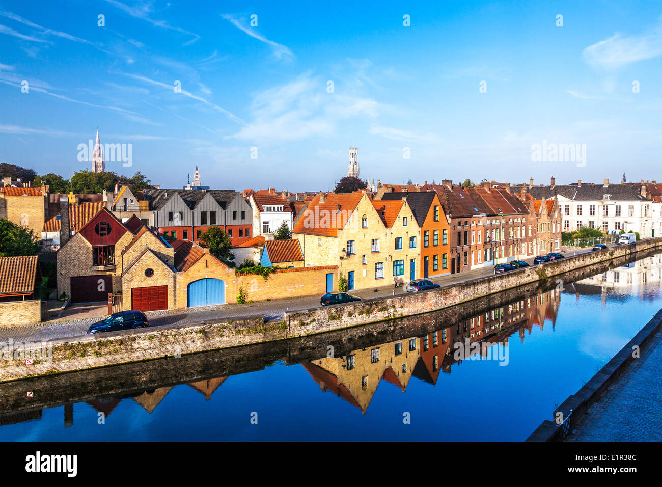 Mittelalterliche Häusern spiegelt sich in den Kanal entlang der Predikherenrei in Brügge, Belgien, mit dem Glockenturm und Türme in der Ferne. Stockfoto