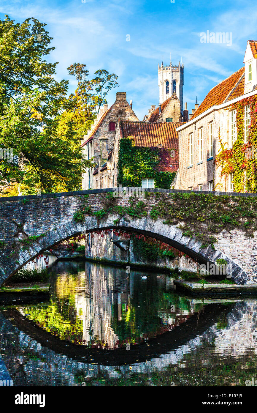 Kanal und Stone Bridge in Brügge, Belgien entlang Steenhouwersdijk mit Glockenturm hinter. Stockfoto