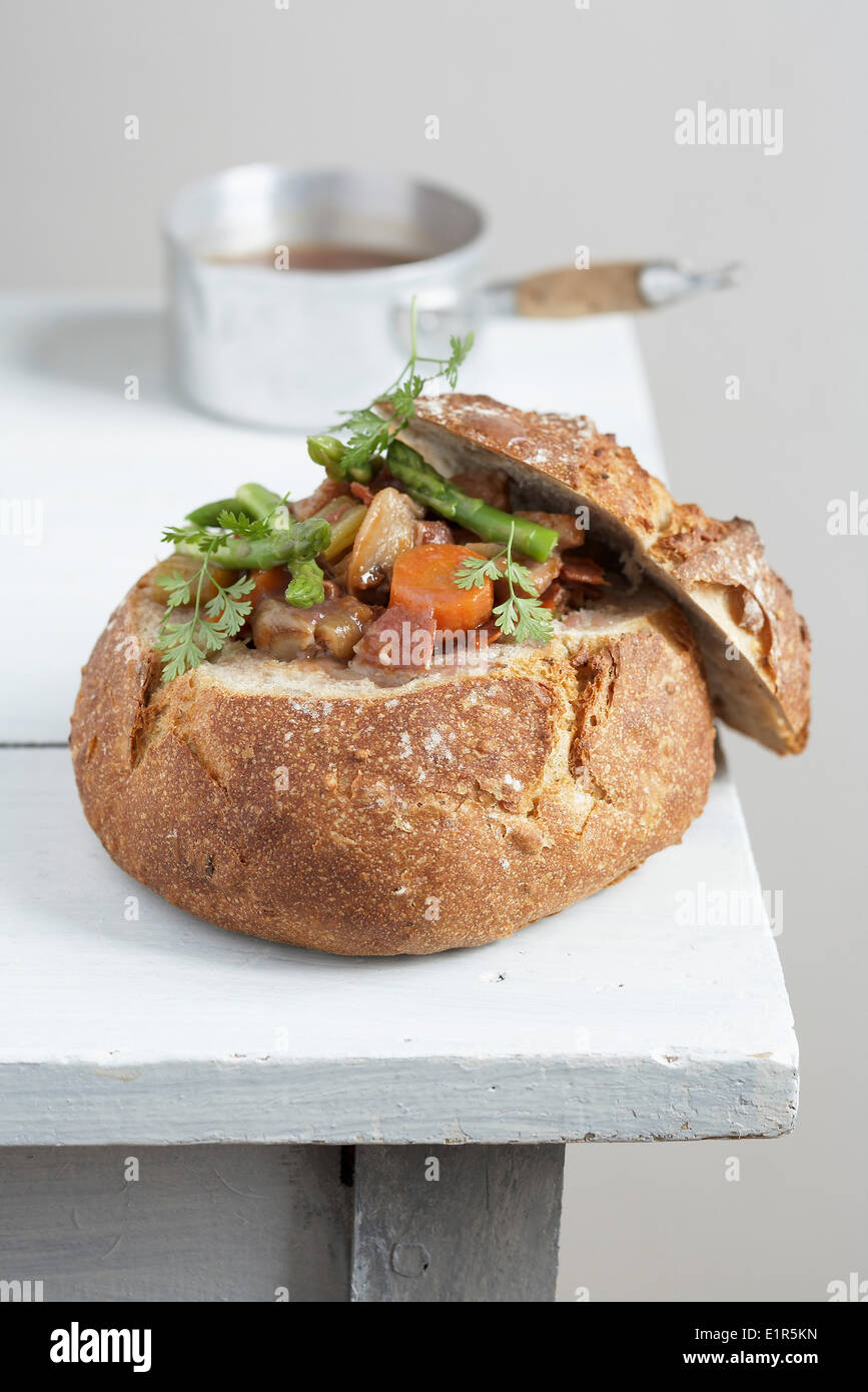 Gedünstetem Gemüse, serviert in einem runden Laib Brot Stockfoto