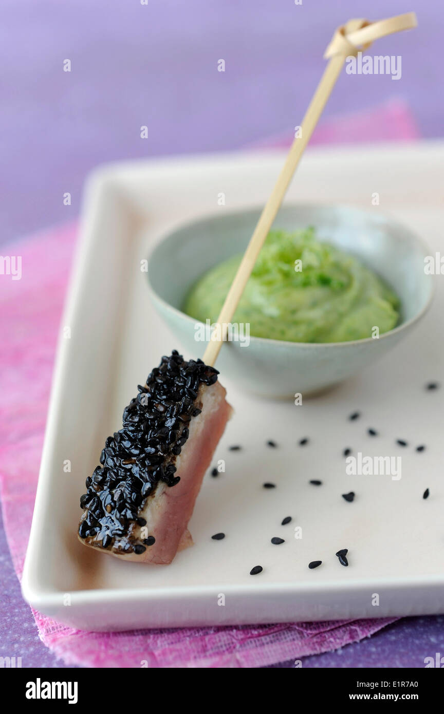 Thunfisch-Sushi mit Sesam, Avocado mit Kräutern und Tabasco Creme Stockfoto