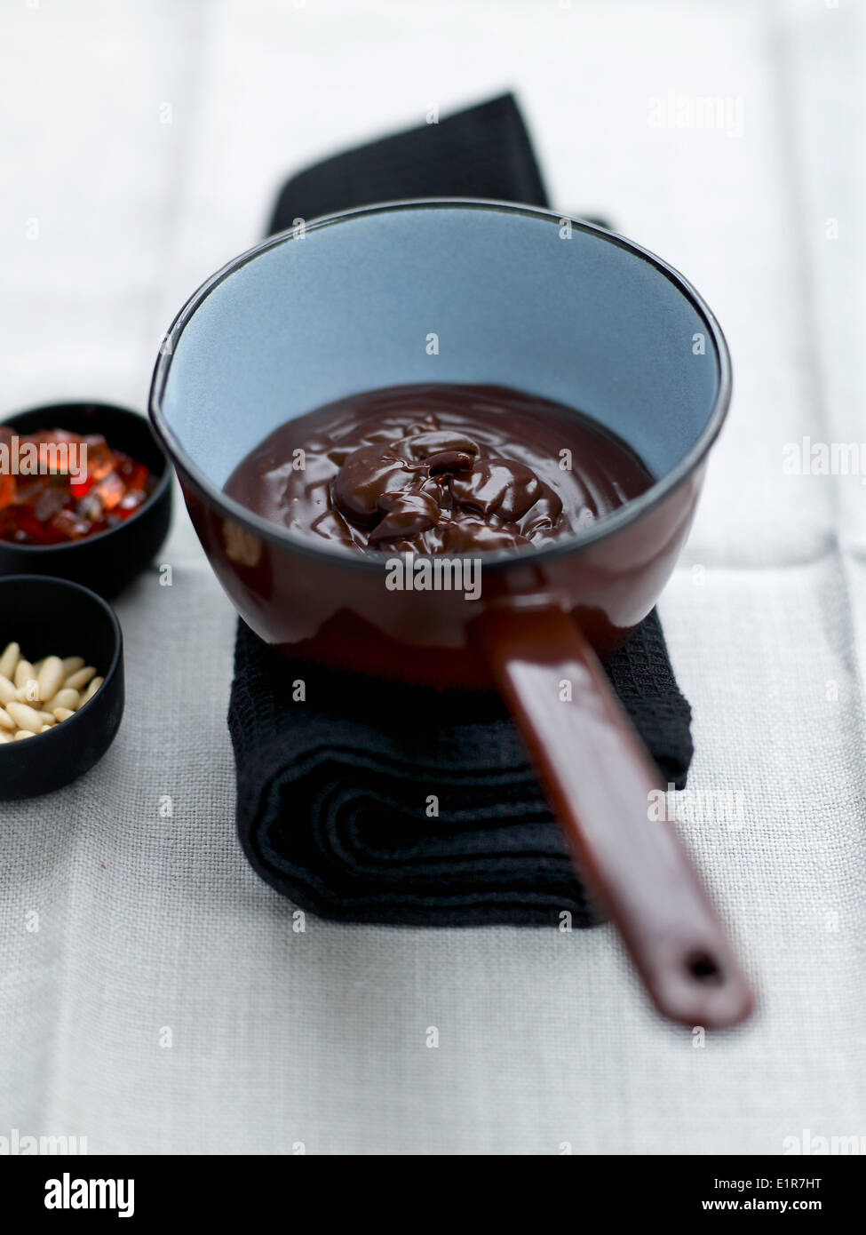 Die Schokoladencreme hinzufügen Pinienkerne und kandierte Früchte Stockfoto