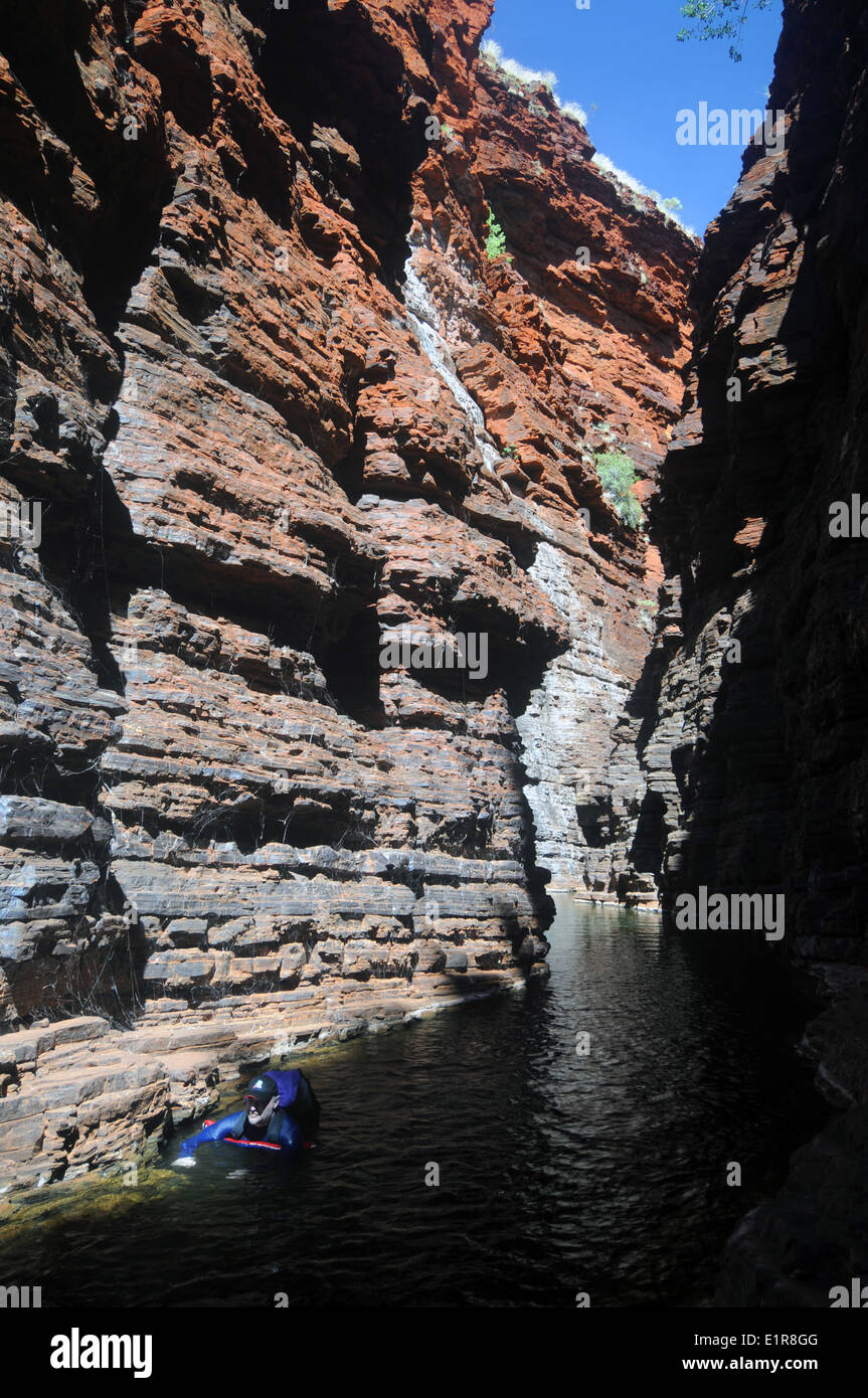 Mann in Anzug und Rucksack Liloing in Joffre Gorge, Karijini-Nationalpark, Hamersley Range, Pilbara, Western Australia. Kein Herr Stockfoto