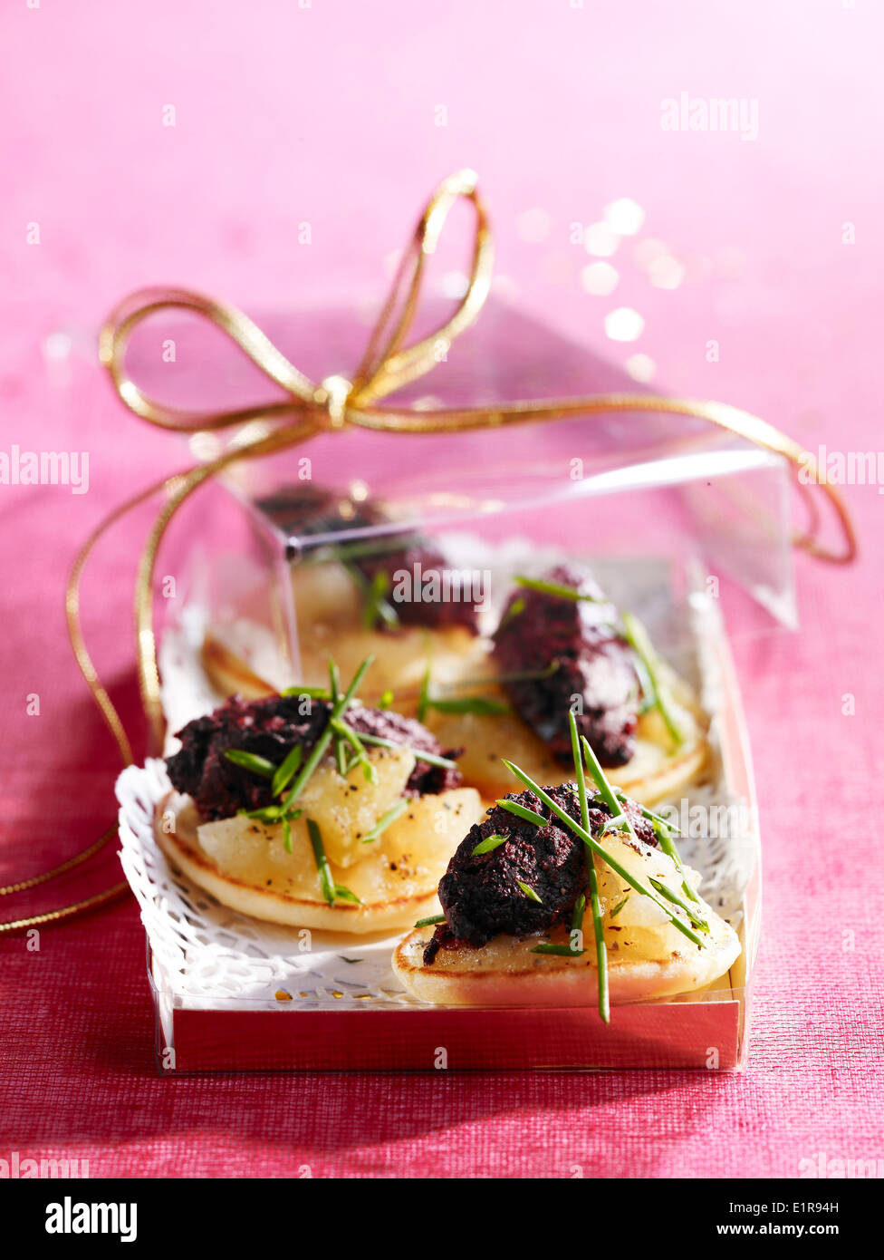 Gedünstete Äpfel und Tapenade auf Mini-blinis Stockfoto