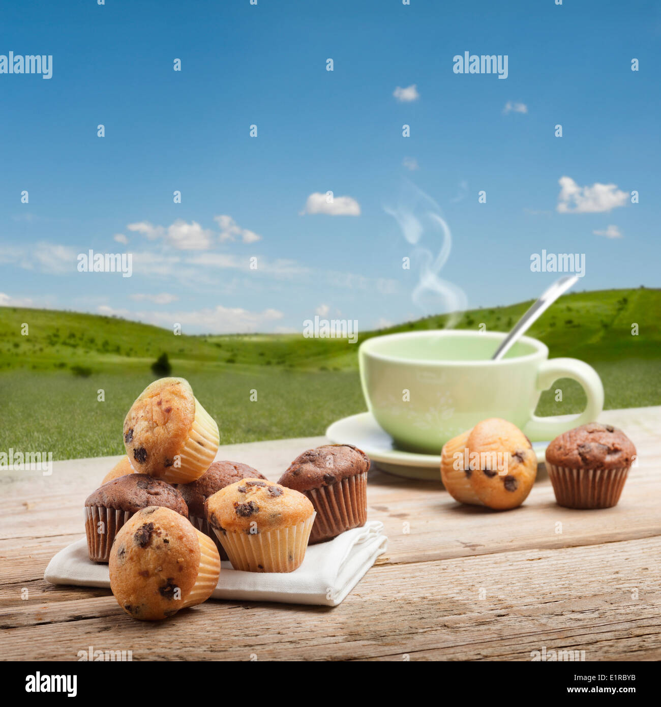 eine Vielzahl von kleinen Muffin mit Tasse Tee auf Holztisch mit Landschaft Hintergrund Stockfoto