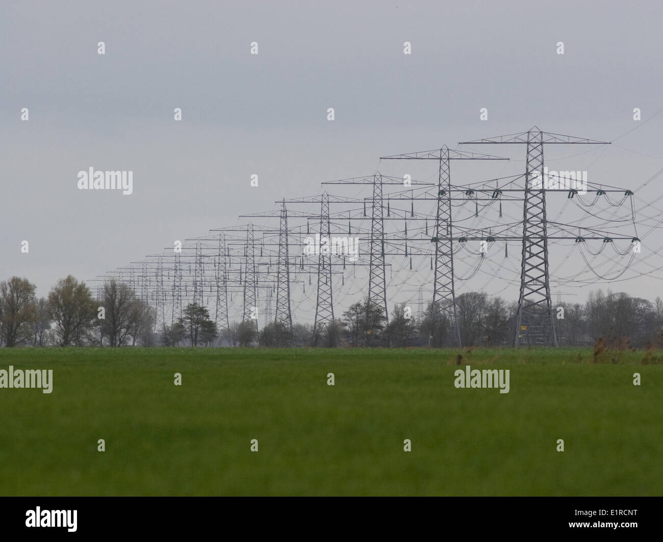Hochspannung Powerlines und Pylonen dominieren die offene Landschaft im Norden der Provinz Groningen. Stockfoto