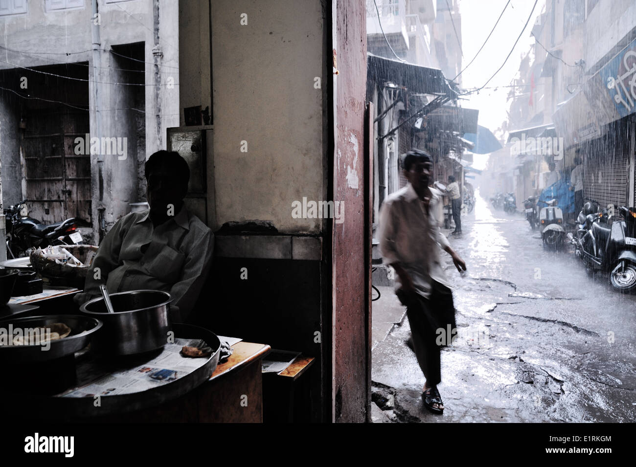 Ein Mann läuft um sich zu schützen gegen starken Regen, Jaipur, Rajasthan, Indien 2012 Stockfoto