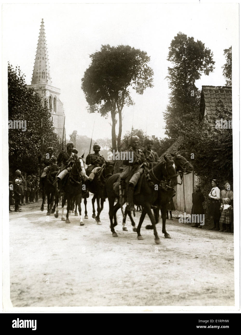 Dieses Bild zeigt indische Kavalleristen, die während des Ersten Weltkriegs durch das Dorf Estrée Blanche marschieren. Es ist Teil der Sammlung, die die Aktionen des Indischen Korps dokumentiert, darunter Einheiten wie die 15. Sikhs und 2/2 Gurkhas in Frankreich. Stockfoto
