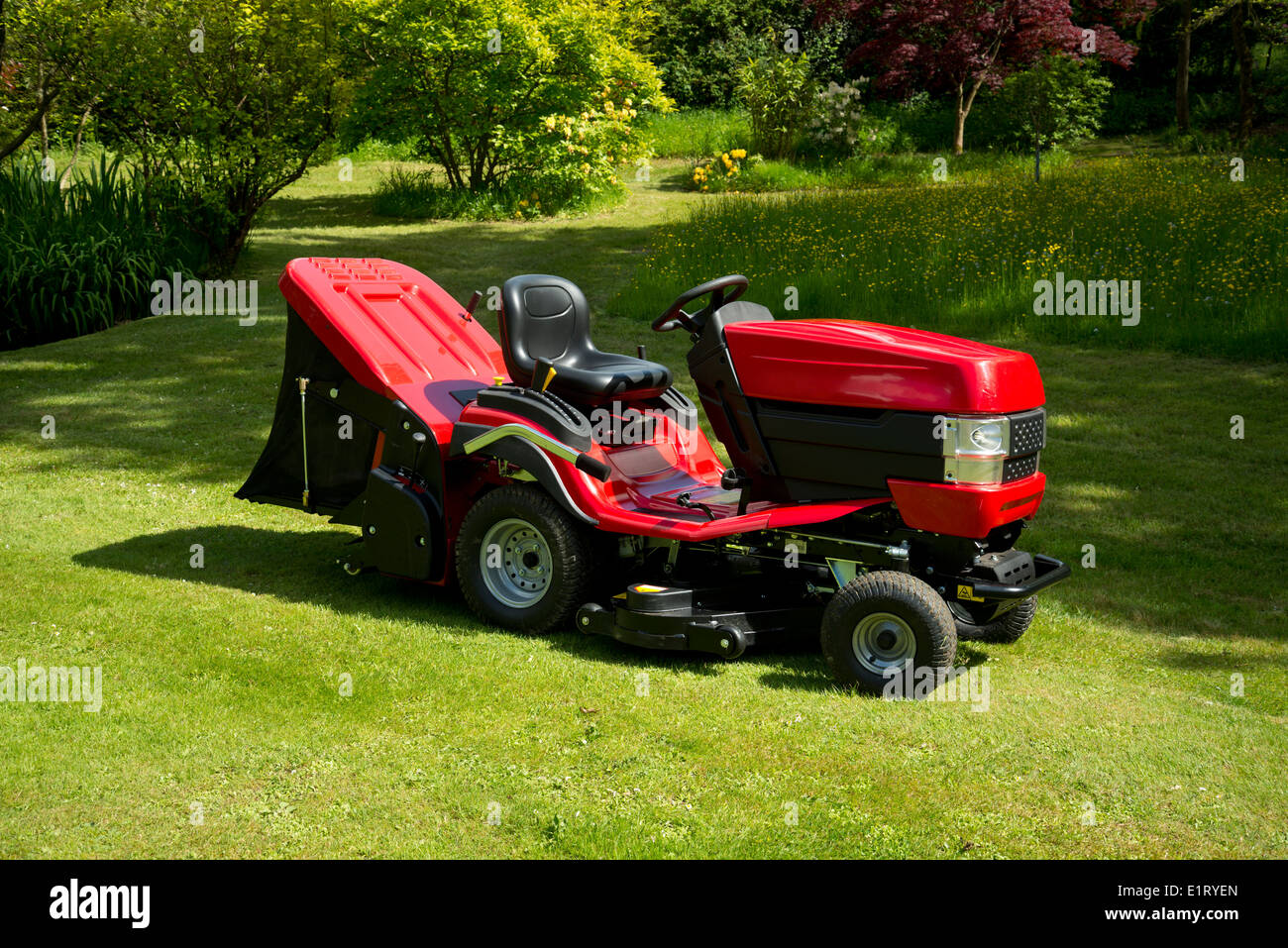 Roter Garten Traktor oder Fahrt auf Mäher, in einem grünen Garten. Stockfoto