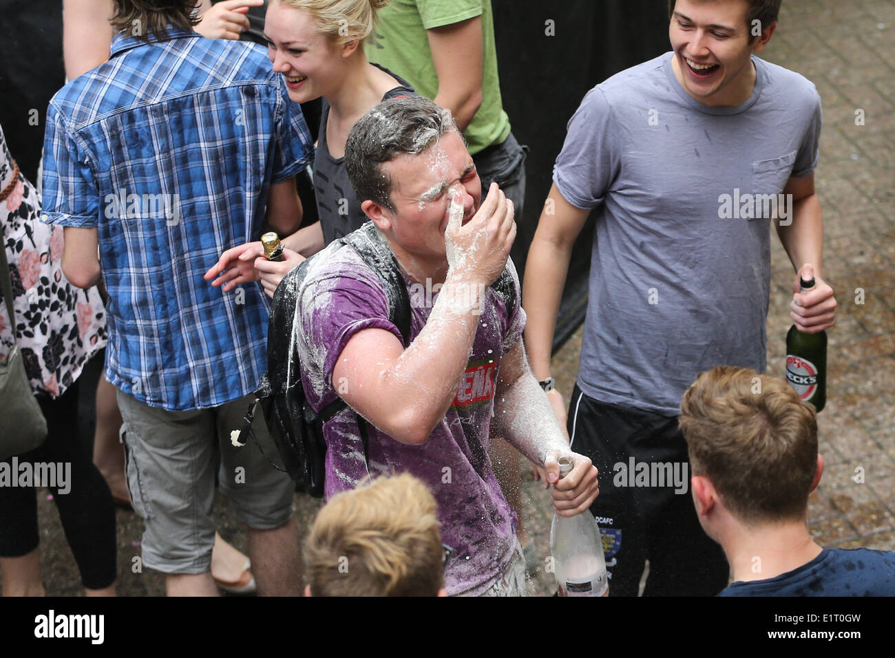 CAMBRIDGE Universität Studenten feiern das Ende der Prüfungen IN der Stadtzentrum werfen Mehl und Champagner. Stockfoto