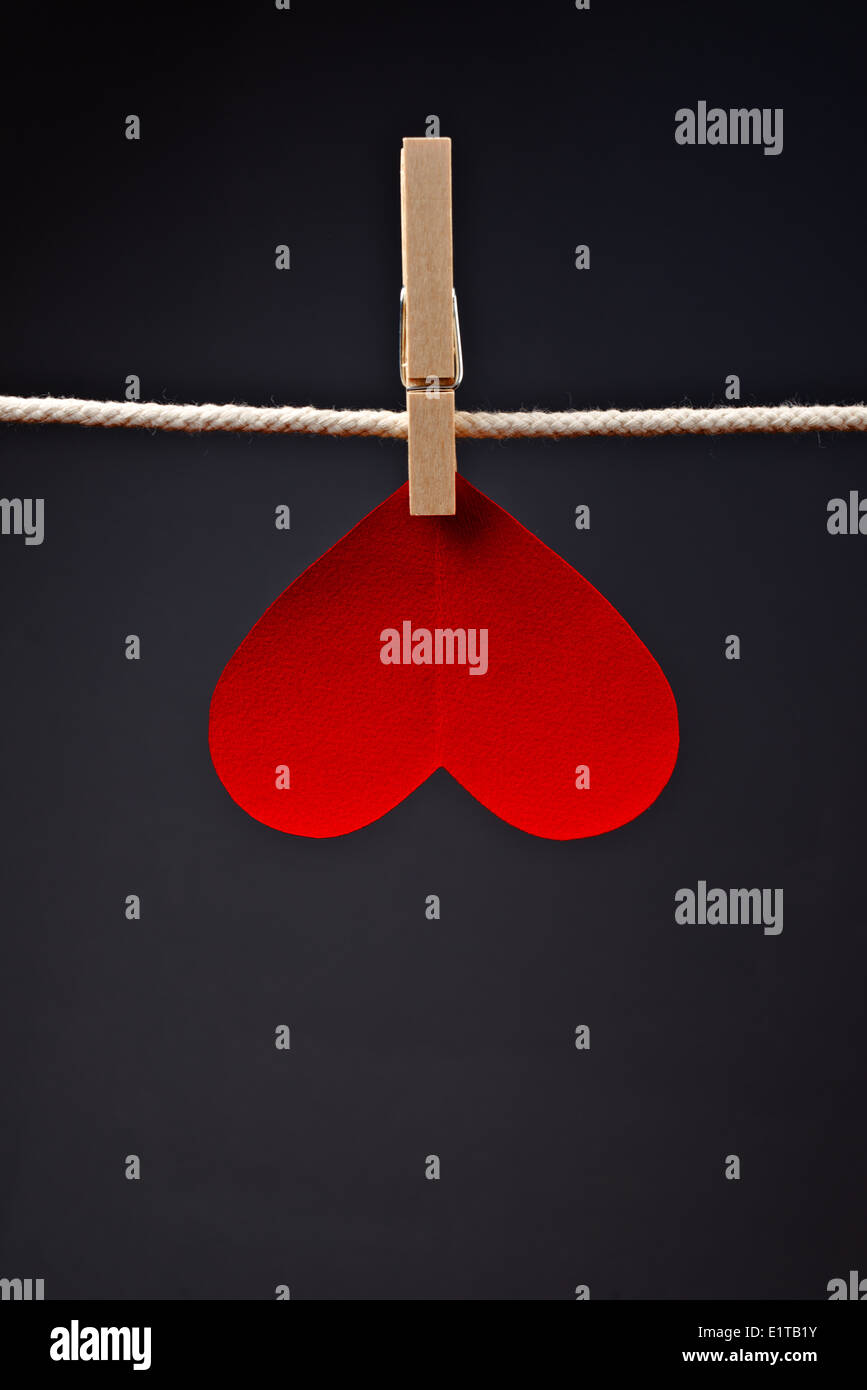 Herzförmige Karte zum Valentinstag mit textfreiraum an einem Seil mit Wäscheklammern befestigt. Romantik, Liebe und Zuneigung Konzept. Stockfoto