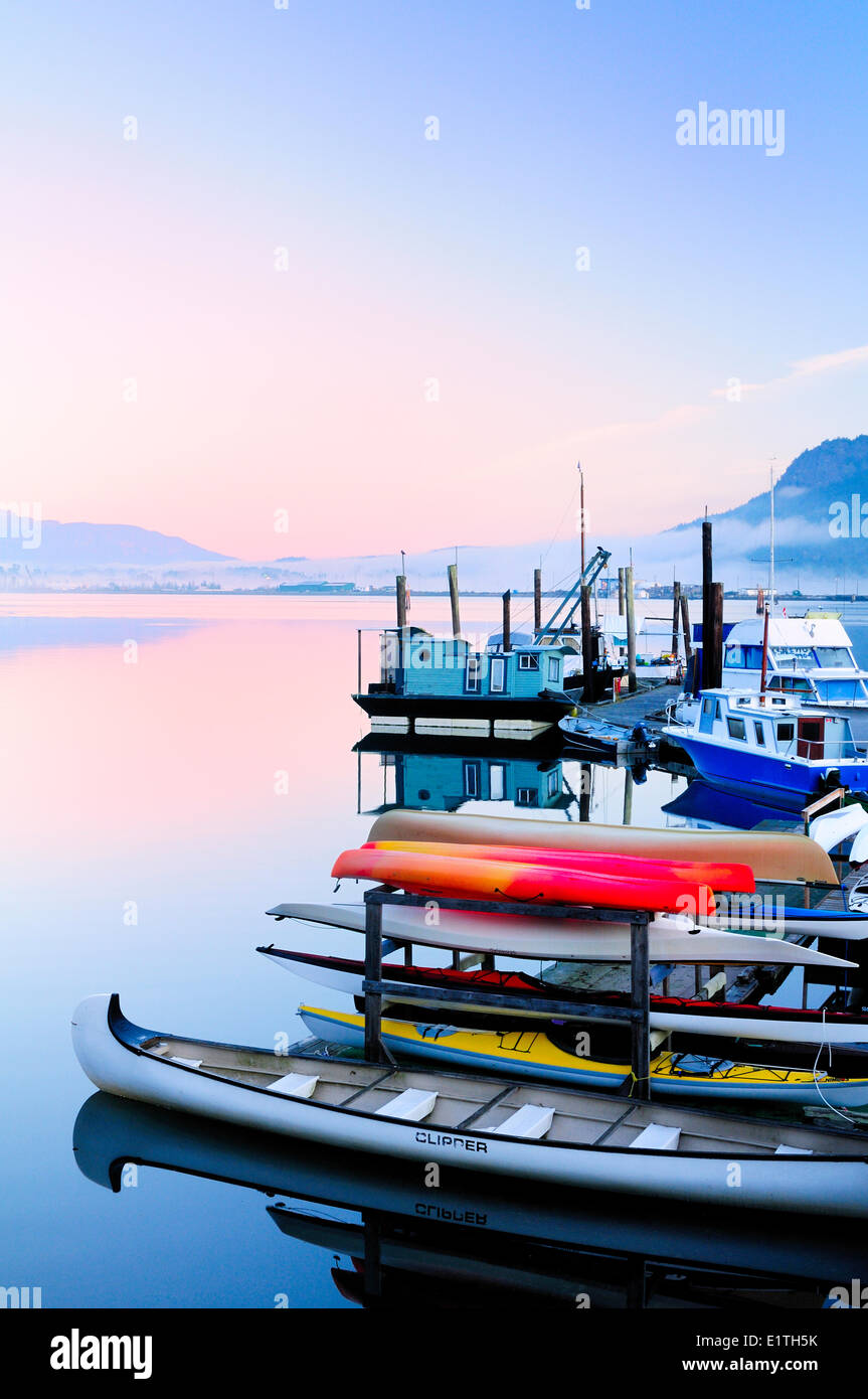 Docks, Kanus, Kajaks und Schwimmer Häuser sitzen in einer Marina in Cowichan Bay, BC im Leerlauf. Stockfoto