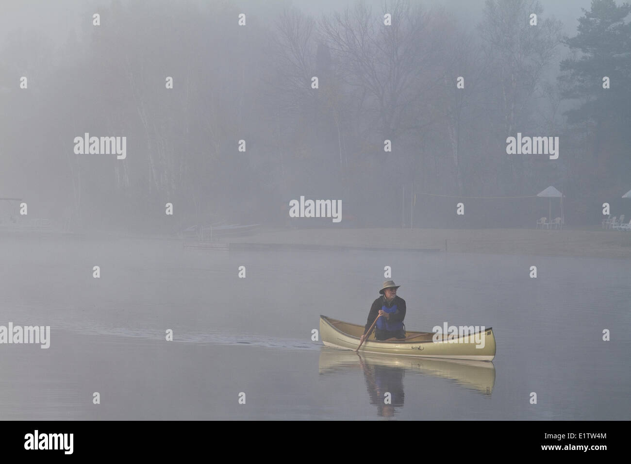 Mann solo Paddel Kanu auf Habichtsbitterkraut See, Muskoka, Ontario. Stockfoto