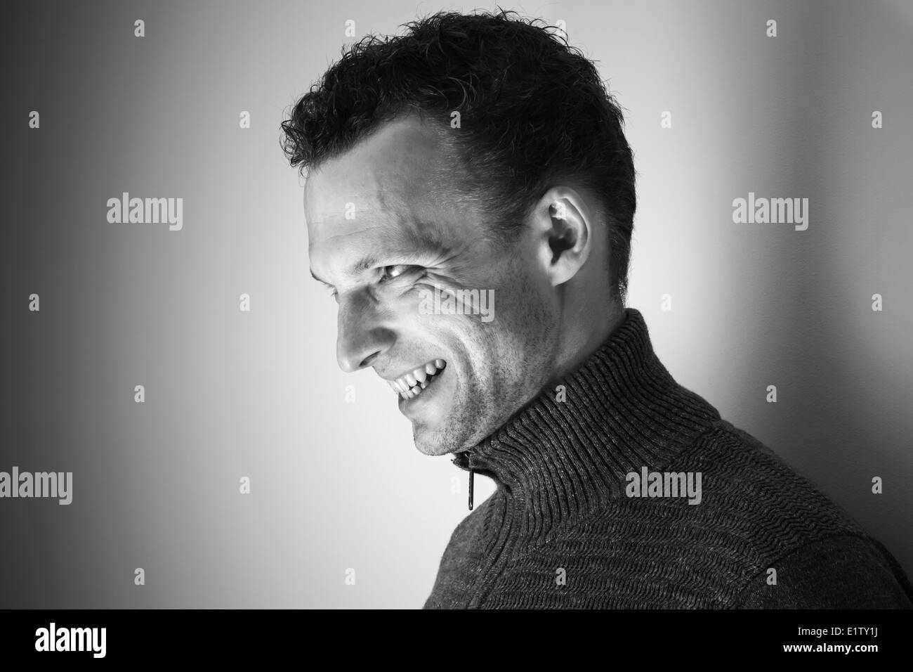 Böse lachenden jungen kaukasischen Mann schwarz / weiß Porträt Stockfoto