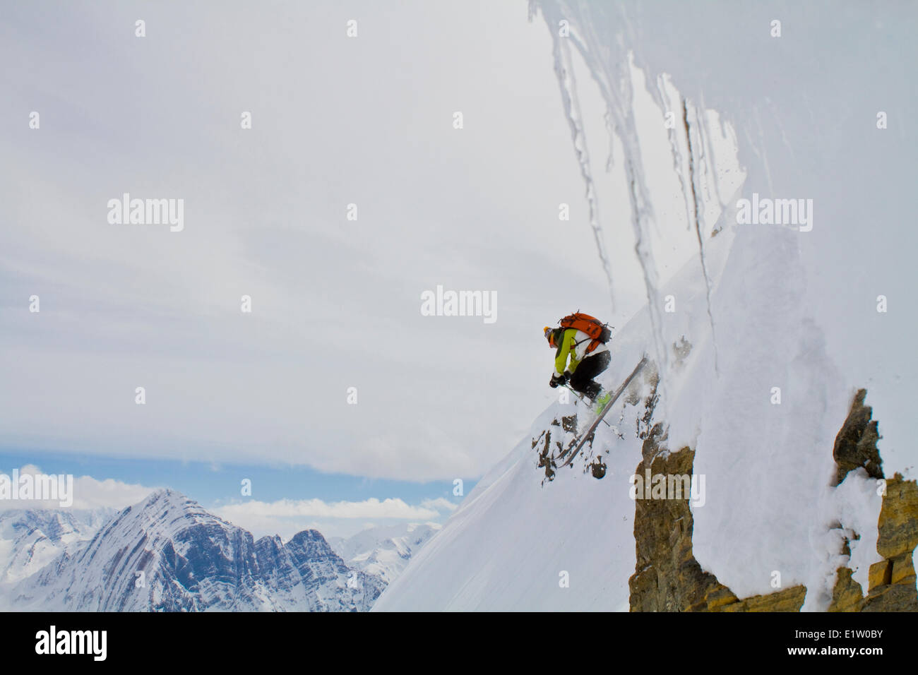 Ein Mann fällt eine Klippe und Skitouren in den kanadischen Rockies. Eisfall Lodge, Golden, BC Stockfoto