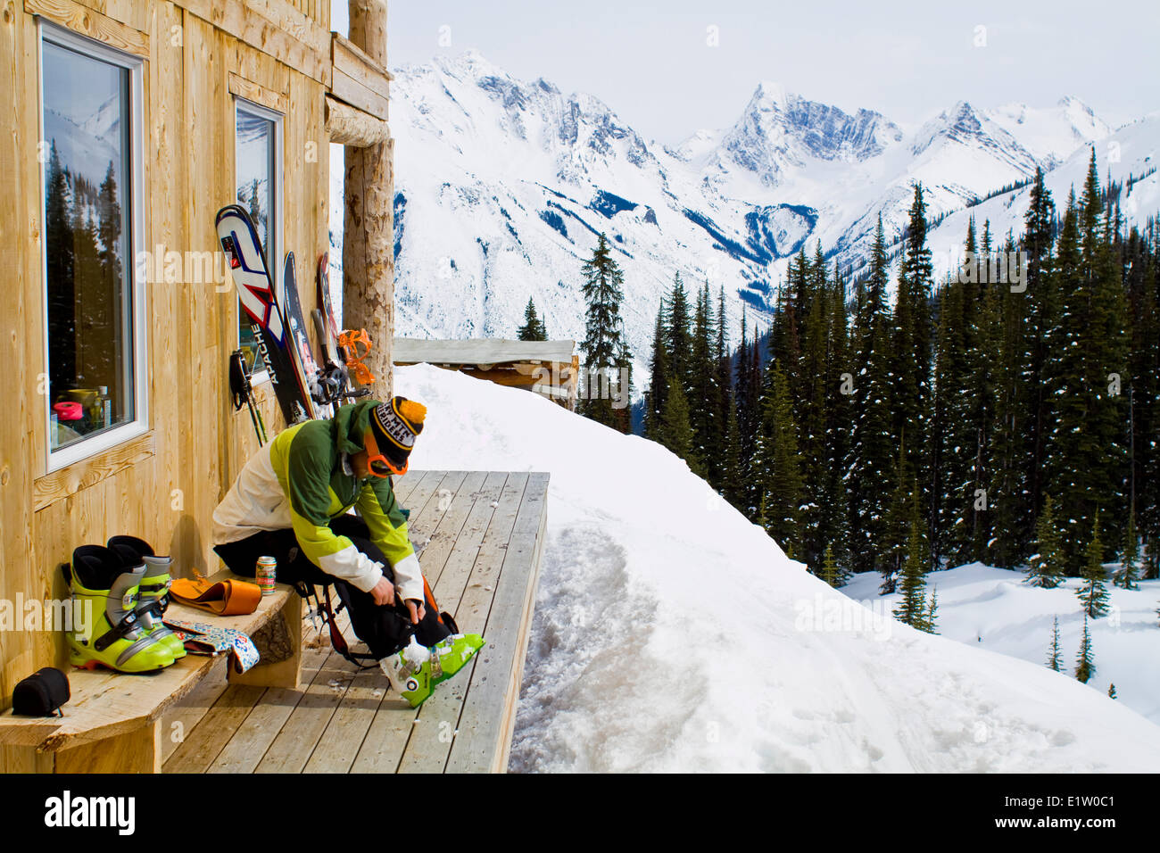 Nach einen tollen Tag Skitouren ruft ein Mann seine Schuhe ausziehen und ein Bier trinken. Eisfall Lodge, Golden, BC Stockfoto
