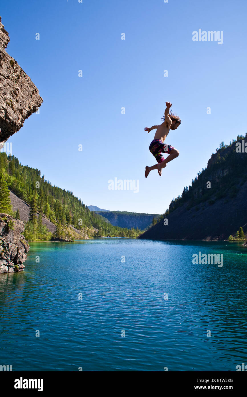 Ein junger Mann Klippen springen in der Nähe von Fernie, BC auf scorching Sommertag. Stockfoto