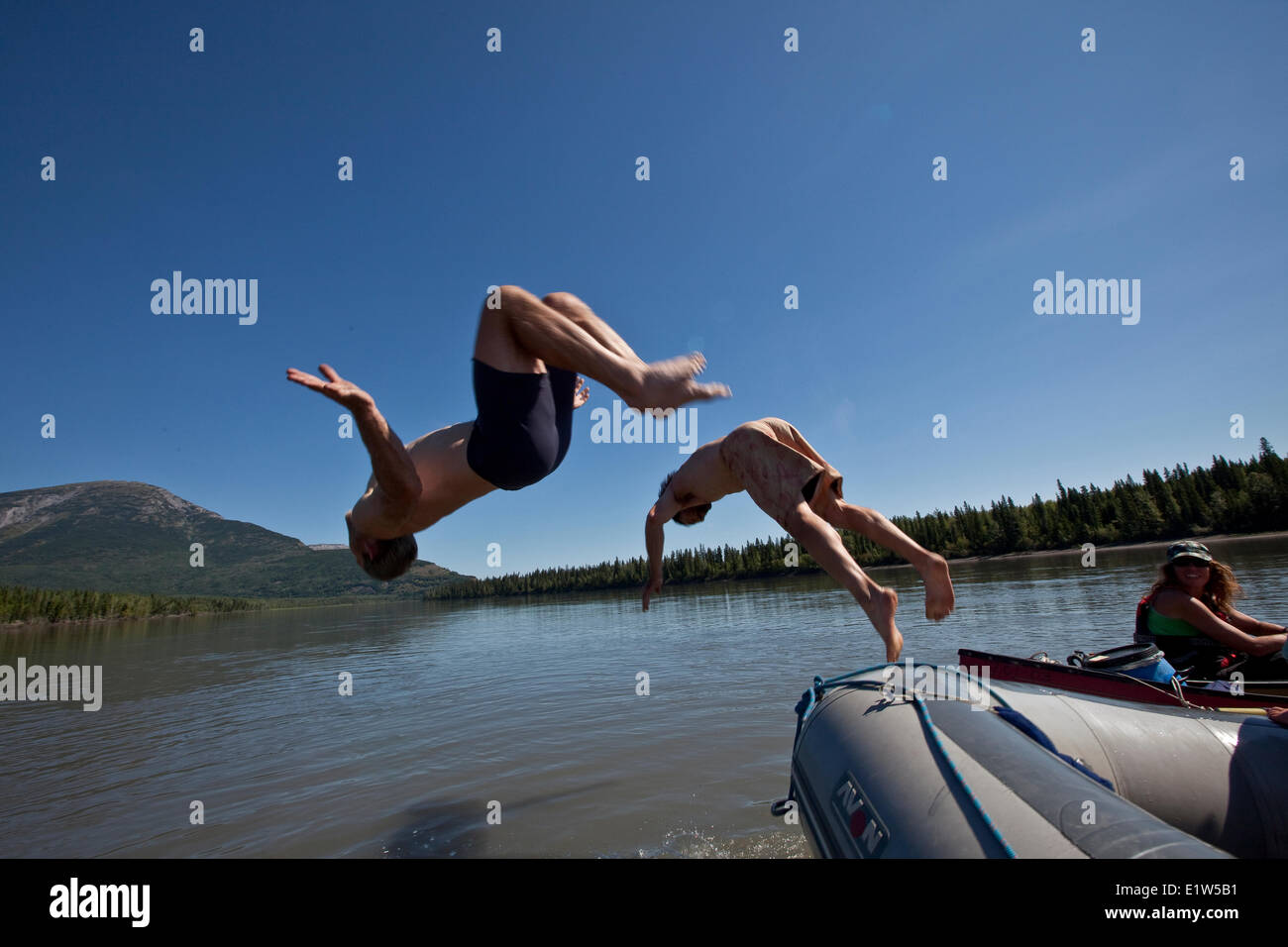 Zwei Männer springen aus Floß in Nahanni River Nahanni National Park zu bewahren, NWT, Kanada. Stockfoto