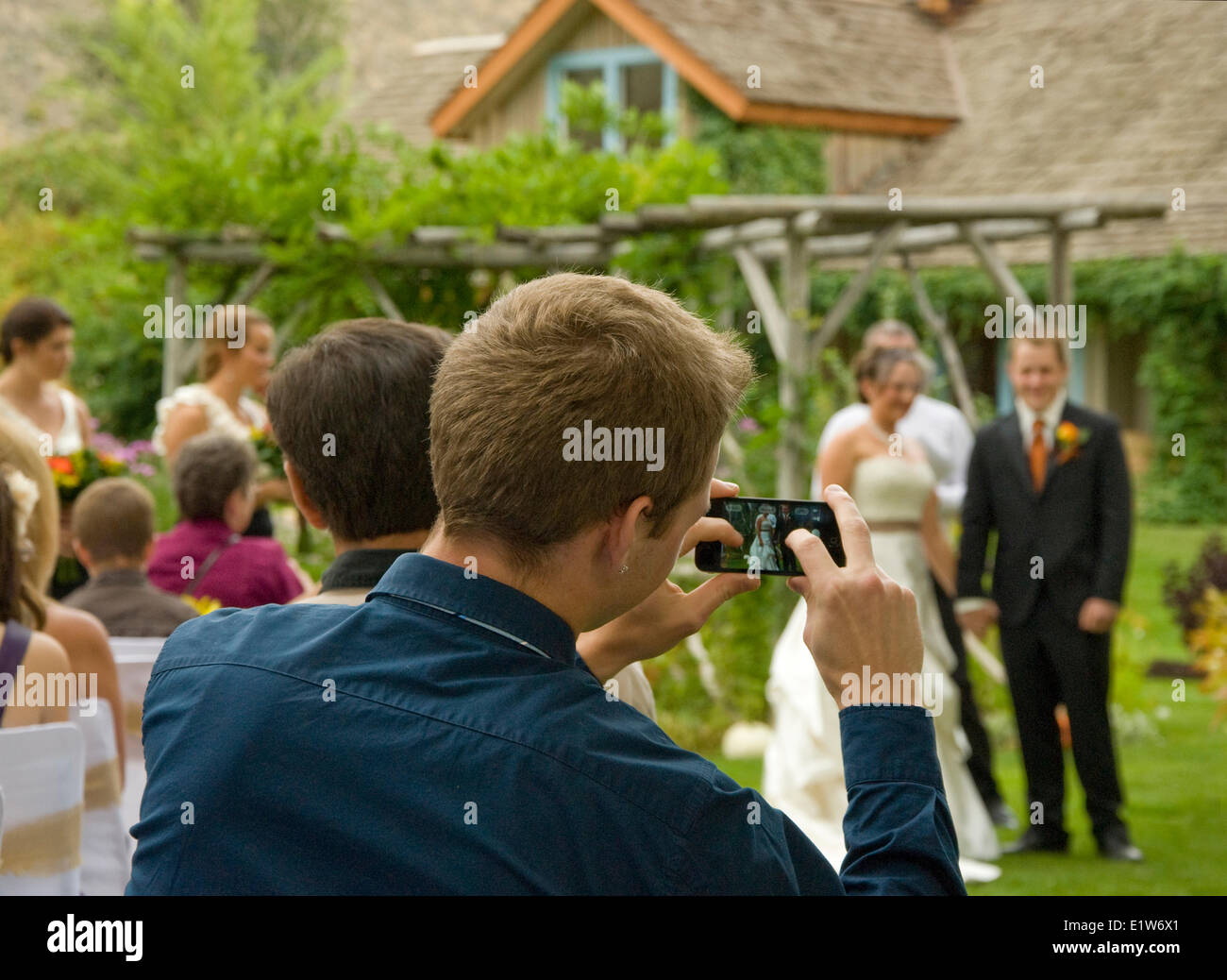 Junge Mann nimmt einer iPhone Bild seine Freunde bei der Grist Mill in der Nähe von Keremeos im Großraum Similkameen britischen Hochzeit Stockfoto