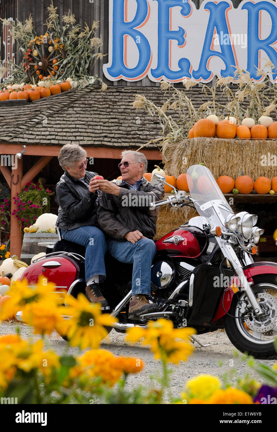 Motorrad touring paar Stopps an einem Obststand in Keremeos im Großraum Similkameen von British Columbia, Kanada Stockfoto