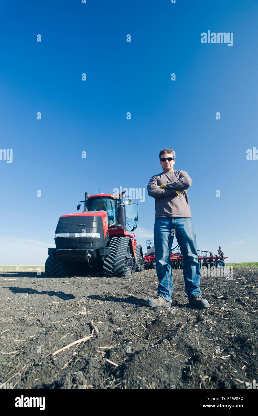 Landwirt vor seinem Quadtrac-Traktor und und Luft bis Sämaschine während der Aussaat Weizen, in der Nähe von Lorette, Manitoba, Kanada Stockfoto