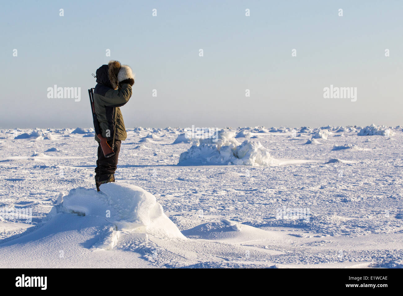 Inuit-Mann Scannen Eis für Eisbären, Westküste Hudson Bay, südlich von Arviat, Nunavut, Kanada Stockfoto