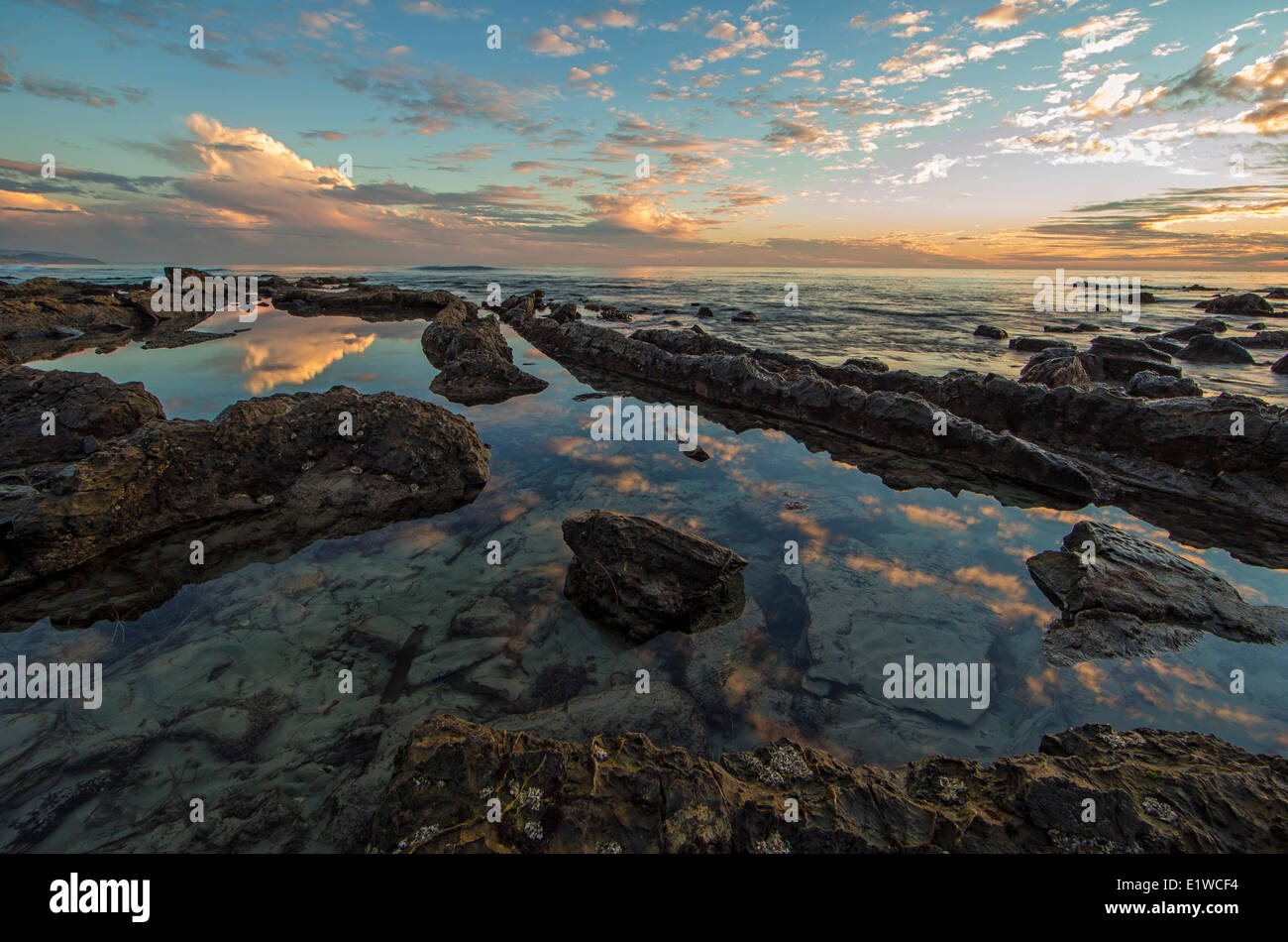 Sonnenuntergang am Crystal Cove State Park in der Nähe von Irvine, Kalifornien. Die Wolken spiegeln sich in einer Ursuppe. Stockfoto