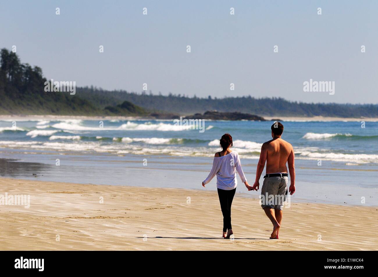 Ein junges Paar gehen Hand in Hand auf Long Beach im Pacific Rim National Park in der Nähe von Tofino, BC. Stockfoto